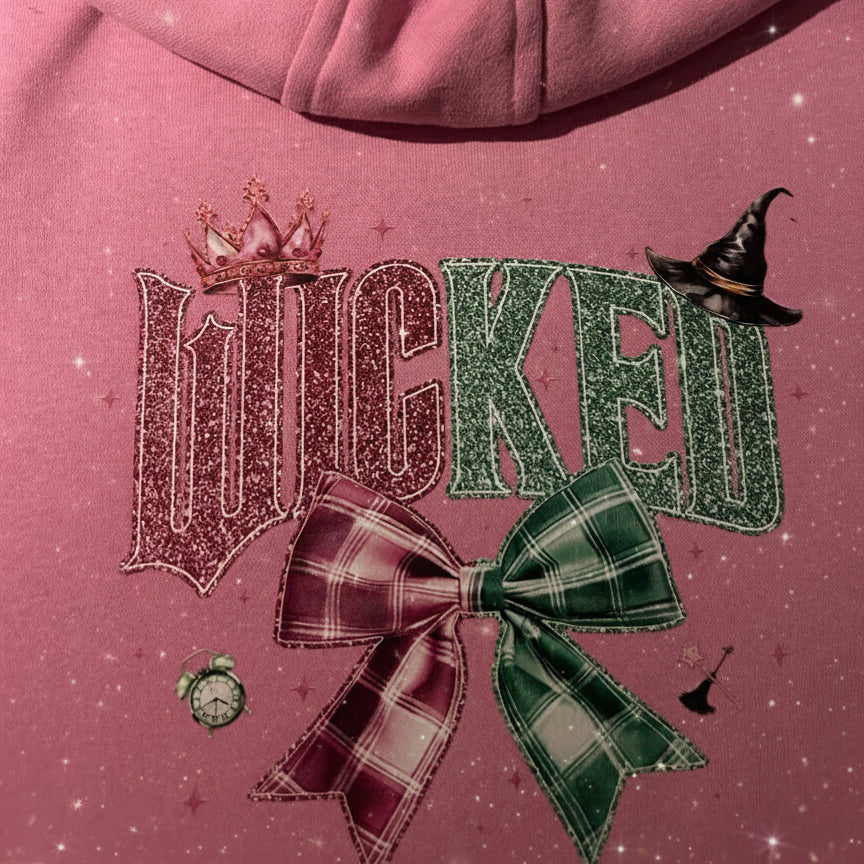 Pink hoodie with 'WICKED' text and decorative elements on a pink background