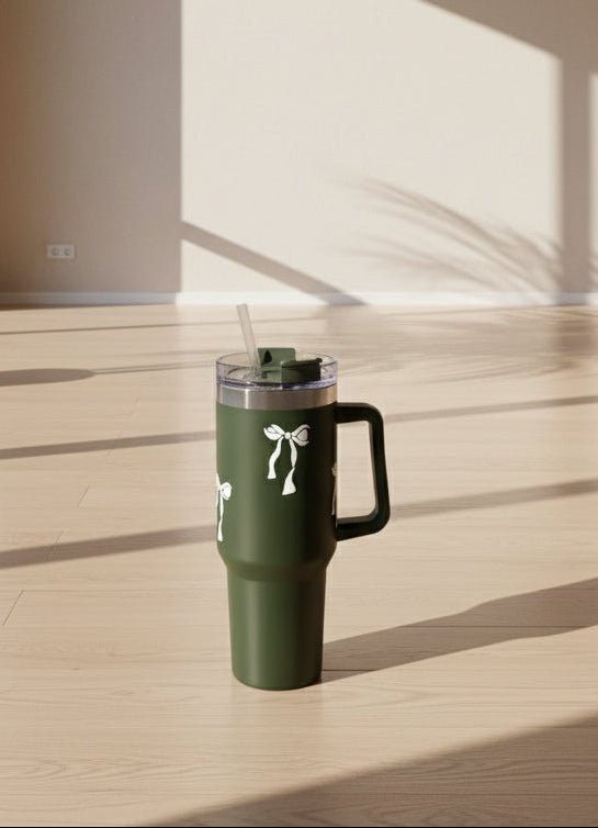 GREEN tumbler with a white logo on a light surface