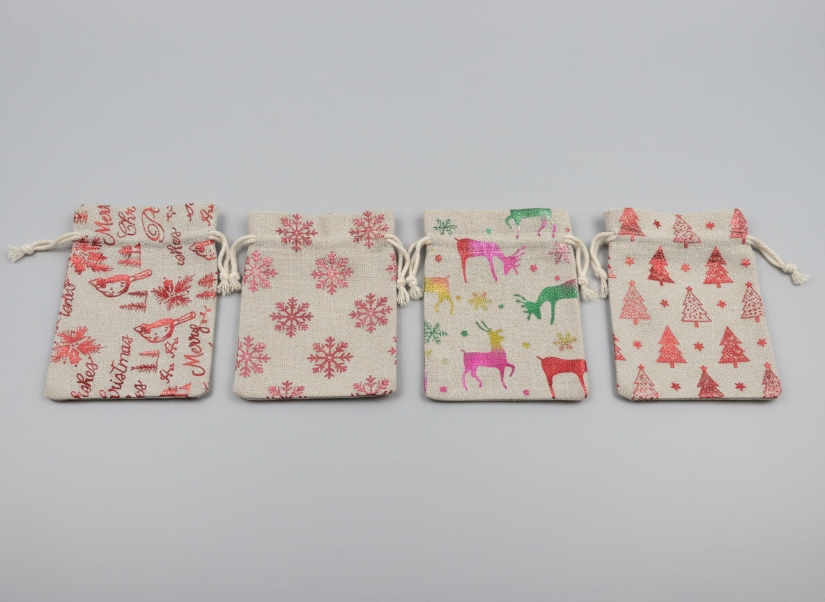 Four fabric pouches with Christmas designs on a laptop keyboard